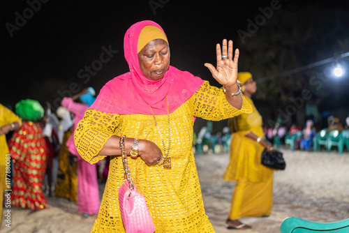 Senegalese woman dancing with raised hand at night celebration photo