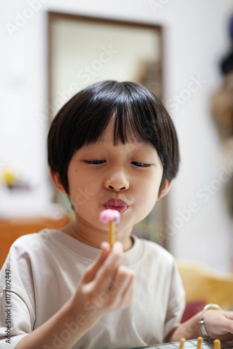 Closeup of an Asian boy playing with handicrafts at home photo