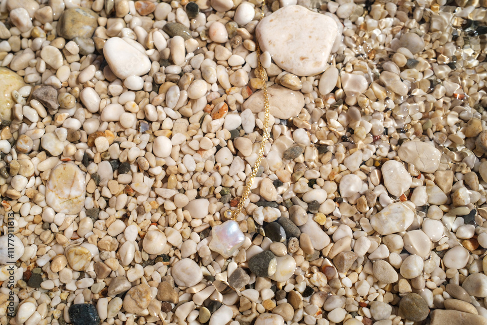 Discovering a beautiful pearl among pebbles on a sunlit beach Discovering a beautiful pearl among pebbles on a sunlit beach