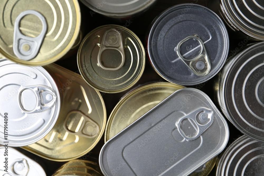 Many closed tin cans on wooden table, flat lay Many closed tin cans on wooden table, flat lay