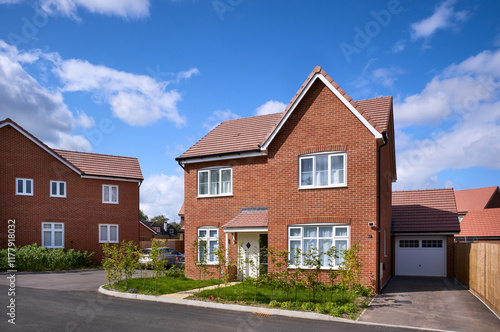 Newly built red brick house with tidy garden on a sunny day photo