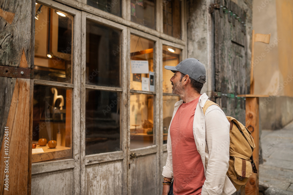 man looking at a shop window in a town in tuscany, italy man looking at a shop window in a town in tuscany, italy