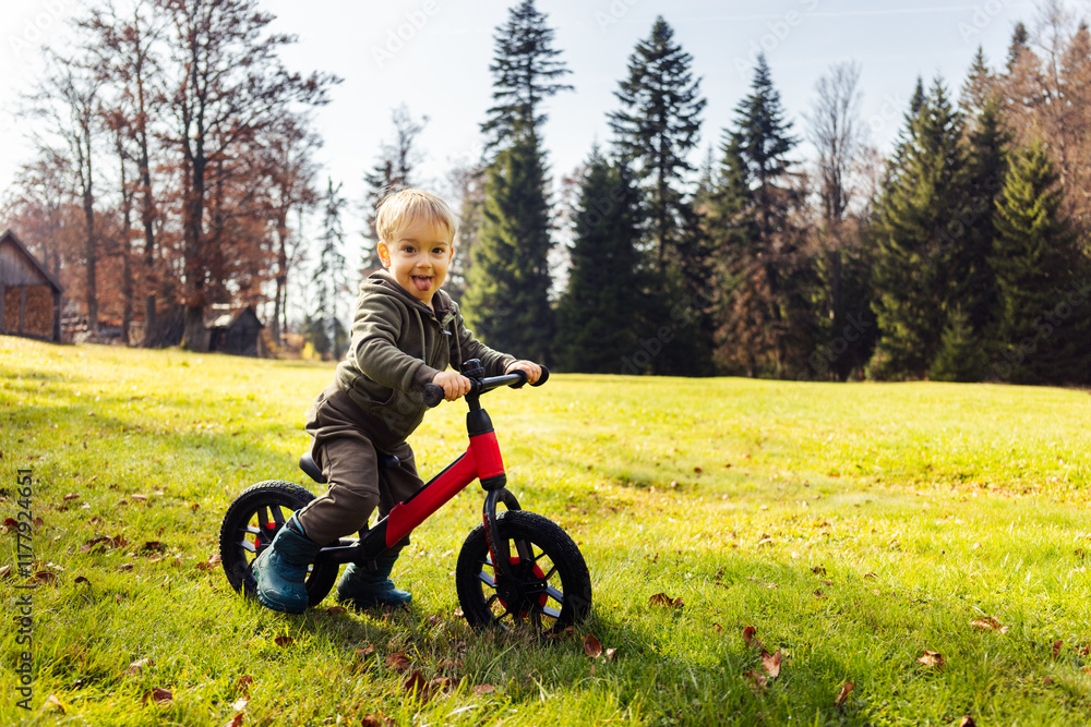 Small kid riding bicycle in garden Small kid riding bicycle in garden