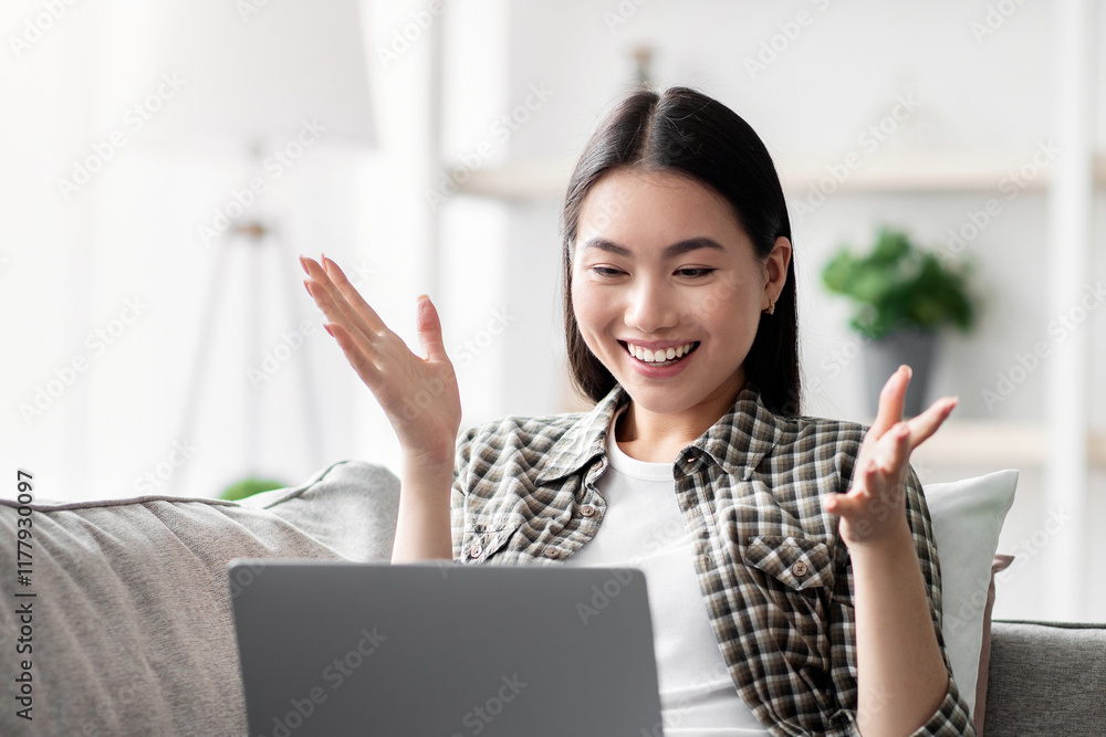 Happy young asian woman having video chat with her lover while spending weekend at home, sitting on couch in cozy living room, using modern laptop, looking at notebook screen and smiling, copy space Happy young asian woman having video chat with her lover while spending weekend at home, sitting on couch in cozy living room, using modern laptop, looking at notebook screen and smiling, copy space