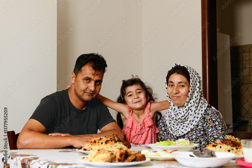Smiling afghan family at the table with national dish