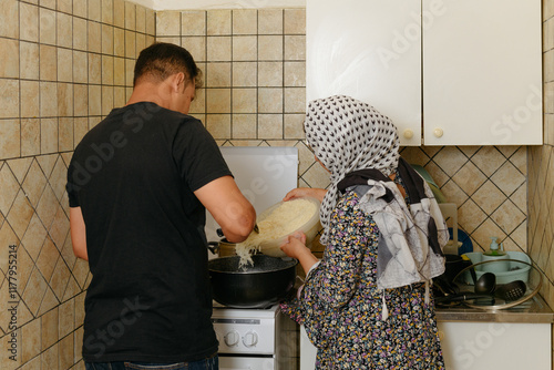 Afghan husband and wife cooking rice in the kitchen photo