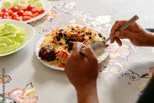 Male hand eating traditional Kabuli Pulao photo