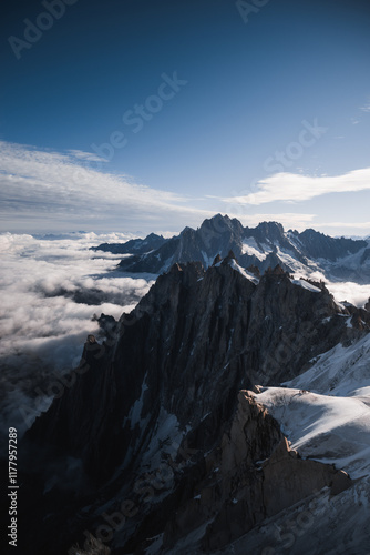 Dramatic alpine peaks of Vallée Blanche surrounded by clouds, located in Mont Blanc massif photo