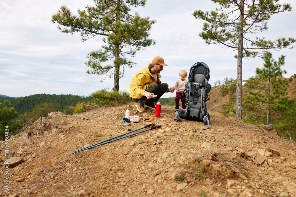 Father and daughter rests on top of a mountain Father and daughter rests on top of a mountain
