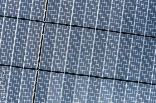 Aerial View of Solar Panels in Grid Pattern Reflecting Sunlight