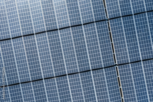 Aerial View of Solar Panels in Grid Pattern Reflecting Sunlight