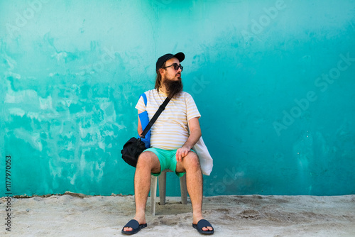 Relaxed Man Sitting by a Teal Wall in Maafushi photo