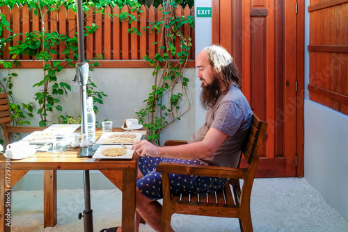 Bearded Man Dining Outdoors on Dhigurah Island
 photo