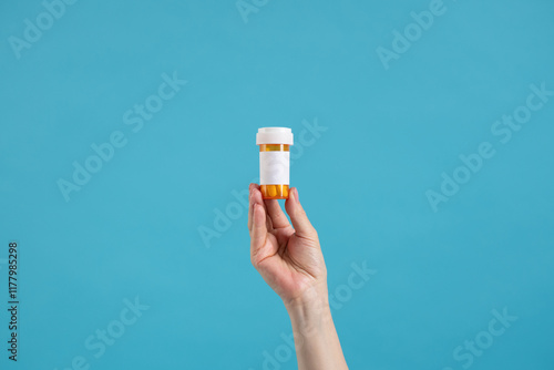 Hand holding prescription pill bottle. Mock up, blank label. 