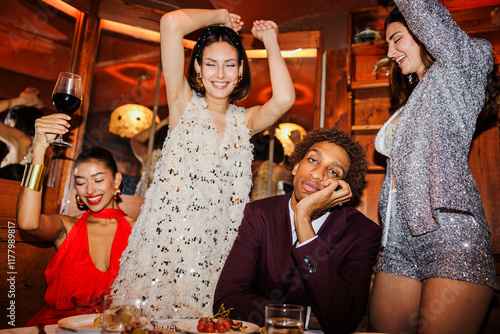 Man sitting at table while friends dancing at New Year's eve ugc photo