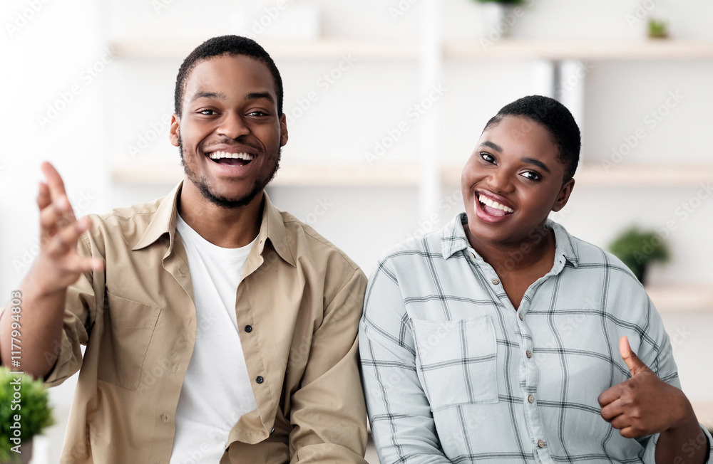 Cheerful Black Couple Talking And Smiling To Camera Gesturing Thumbs Up Communicating Online Via Video Call Sitting At Home. Portrait Of Happy Customers Gesturing Like. Selective Focus Cheerful Black Couple Talking And Smiling To Camera Gesturing Thumbs Up Communicating Online Via Video Call Sitting At Home. Portrait Of Happy Customers Gesturing Like. Selective Focus