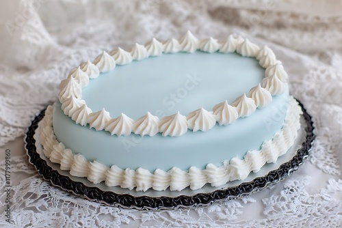 A delicate oval birthday cake with pale blue icing and intricate white piping, resembling fine china, on an antique lace tablecloth.
