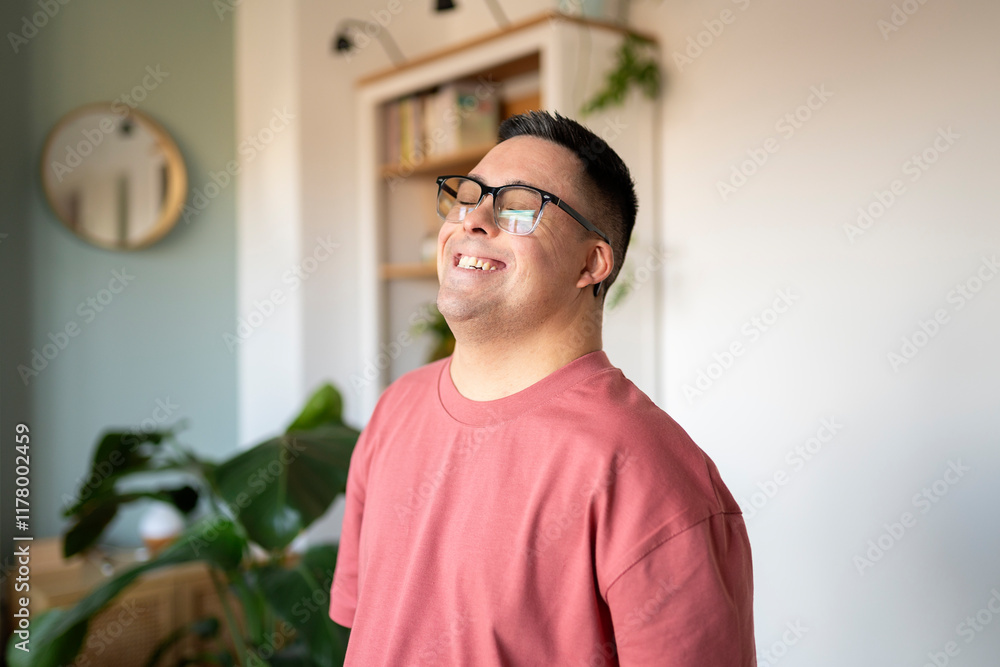 Man with Down syndrome smiling in cozy living room Man with Down syndrome smiling in cozy living room