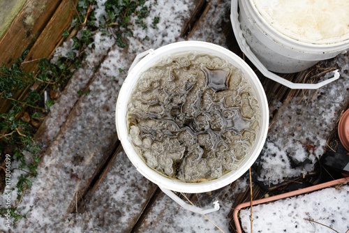 Plastic bucket of ice water left outside in the cold photo