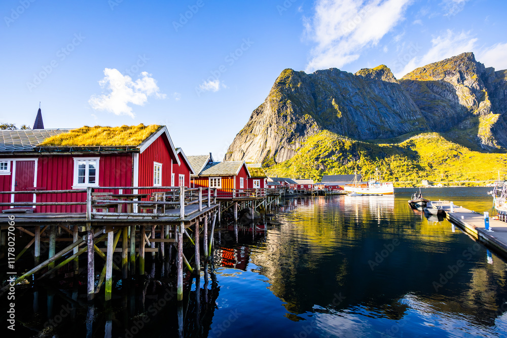 Fototapeta premium A beautiful sunrise over the picturesque village of Reine in Lofoten Islands, Norway, surrounded by dramatic mountains.