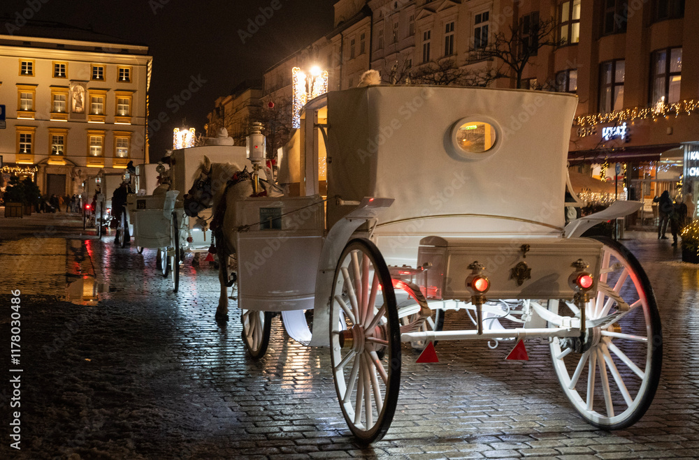 elegancka biała dorożka konna na ulicach Krakowa wieczorową porą
