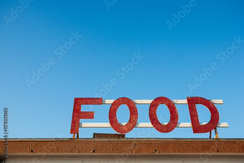 Vintage Food Sign Against Blue Sky
 photo