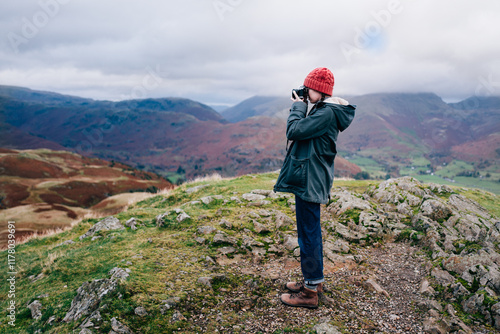 Taking a photo with an analogue camera from the top of a mountain photo