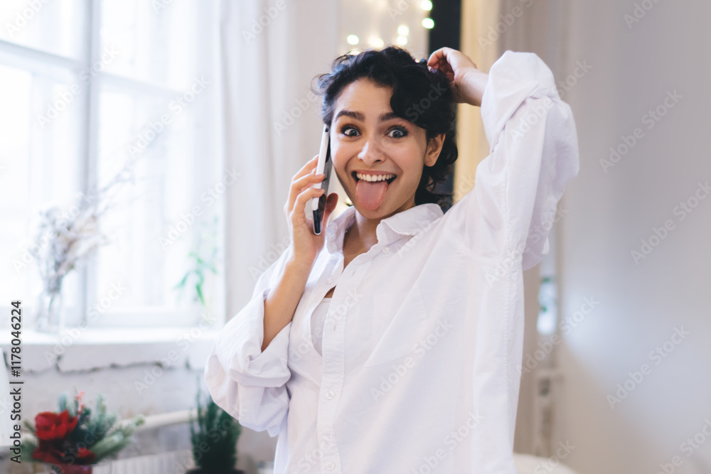 Optimistic woman showing tongue during phone call Optimistic woman showing tongue during phone call