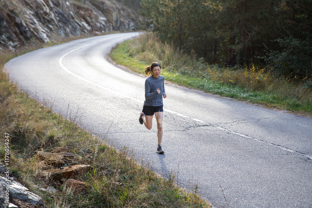 © Jovo Jovanovic/Stocksy - Determined woman in sportswear jogging on road