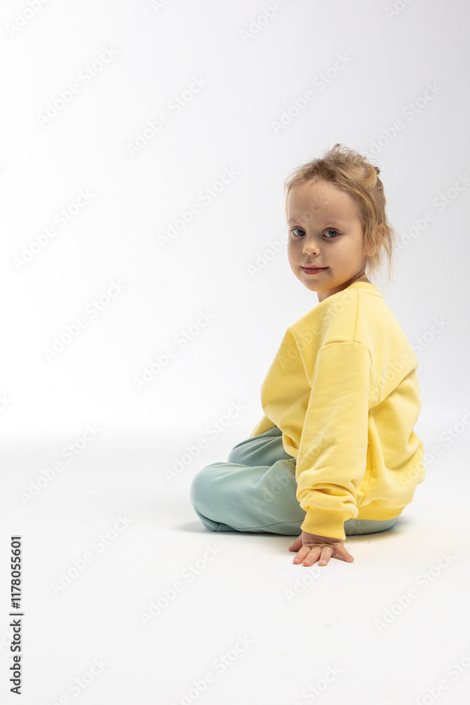 Portrait of beautiful cute little toddler girl. Child with funny face in yellow sweatshirt. Pretty smile kid in studio on white background. High quality photo Portrait of beautiful cute little toddler girl. Child with funny face in yellow sweatshirt. Pretty smile kid in studio on white background. High quality photo
