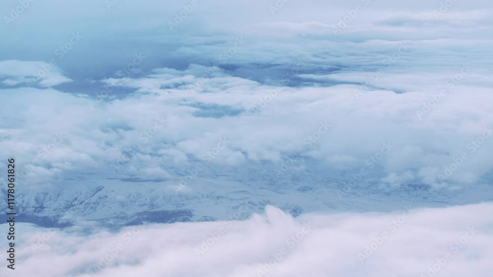 An aerial view through the clouds, showcasing snow-covered mountains and natural landscapes. Perfect for themes related to air travel,scenery, or the sky, offering a stunning and serene. An aerial view through the clouds, showcasing snow-covered mountains and natural landscapes. Perfect for themes related to air travel,scenery, or the sky, offering a stunning and serene.