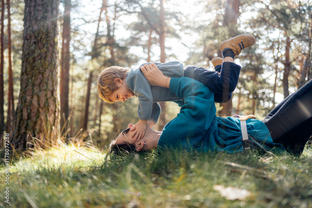 Parent and child playing in the forest sunlight Parent and child playing in the forest sunlight