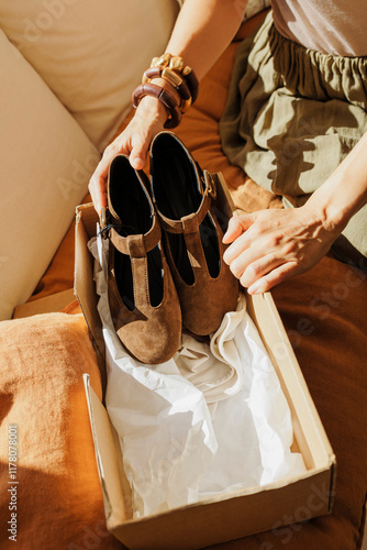 Woman unboxing stylish brown shoes at home photo