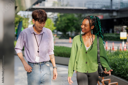 Happy male and female colleagues discussing outdoors photo