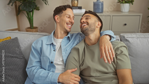 Loving men couple sharing a joyful moment on their living room couch, illustrating gay love, family bond, and the cozy indoor atmosphere of their home. photo