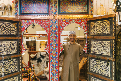 Omani shopkeeper welcoming customers at traditional market stall photo