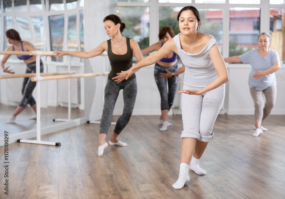 Group of women of different ages are learning various dance and ballet movements in the studio Group of women of different ages are learning various dance and ballet movements in the studio
