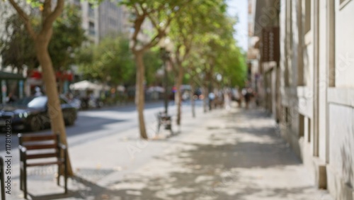 Obraz na plátně Outdoor scene with blurred trees and buildings along a sunny sidewalk in a city