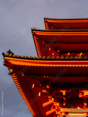 Sunlit Traditional Japanese Temple Roof Against Dramatic Sky photo