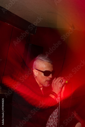 Energetic singer performing on stage with vibrant lighting photo