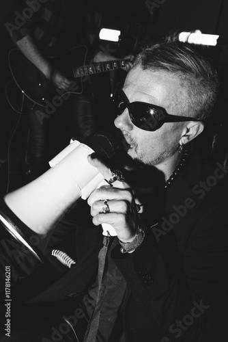 Expressive rock singer performing with megaphone on stage photo