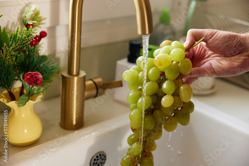 Washing grapes under the faucet photo