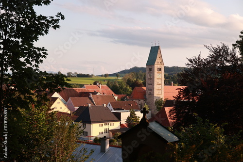 A small town with a church tower in the background photo