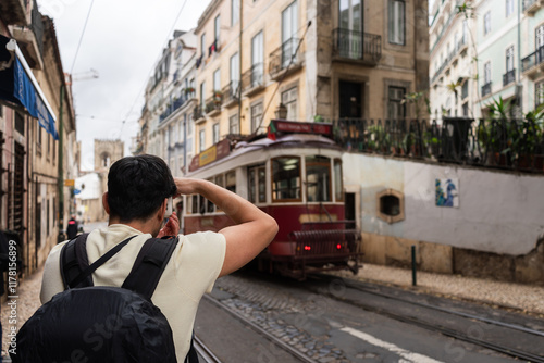 Tourist taking photo of traditional tram in lisbon, portugal photo