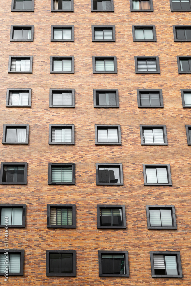 Fototapeta premium Beautiful brick residential building, with square windows, texture of the facade of a residential area, modern architecture and design in the city