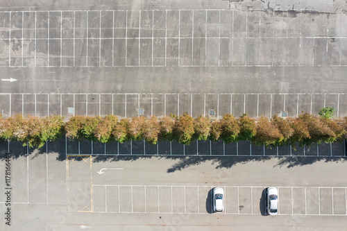 Aerial view of empty parking lot with two cars and trees photo