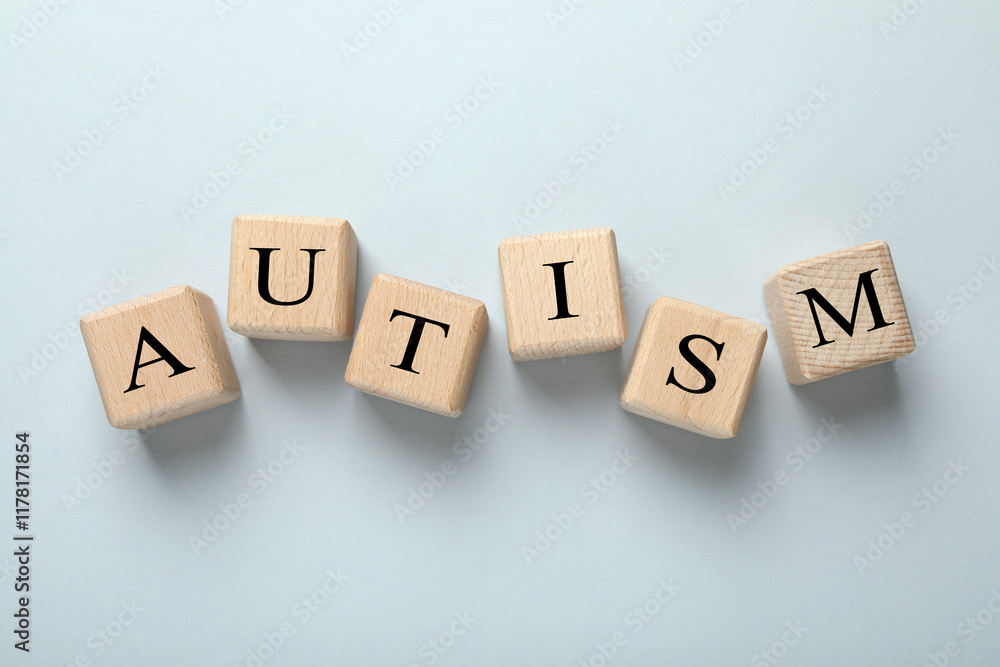 Word Autism made with wooden cubes on grey background, flat lay Word Autism made with wooden cubes on grey background, flat lay