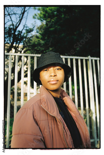 Portrait of African woman wearing a pink puffer jacket at golden hour photo