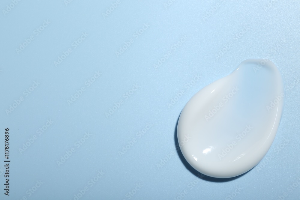 Cream sample on light blue background, top view. Space for text Cream sample on light blue background, top view. Space for text