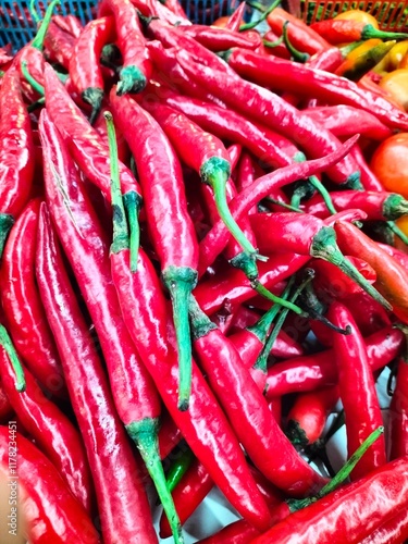 A vibrant close-up image of fresh red chili peppers with a glossy texture and green stems. Perfect for themes related to spicy food, culinary ingredients, organic produce, and food photography photo